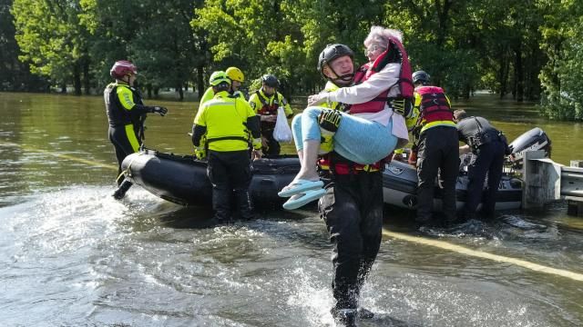 Conroe firefighter Cody Leroy carries a resident evacuated in a boat by the CFD Rapid Intervention Team from her flooded home in the aftermath of a severe storm, Thursday, May 2, 2024, in Conroe, Texas. (Brett Coomer/Houston Chronicle via AP)