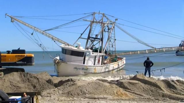 A shrimp boat that washed ashore in Myrtle Beach, South Carolina, by Hurricane Ian was finally freed from the sand on Tuesday with the help of a backhoe and another boat.