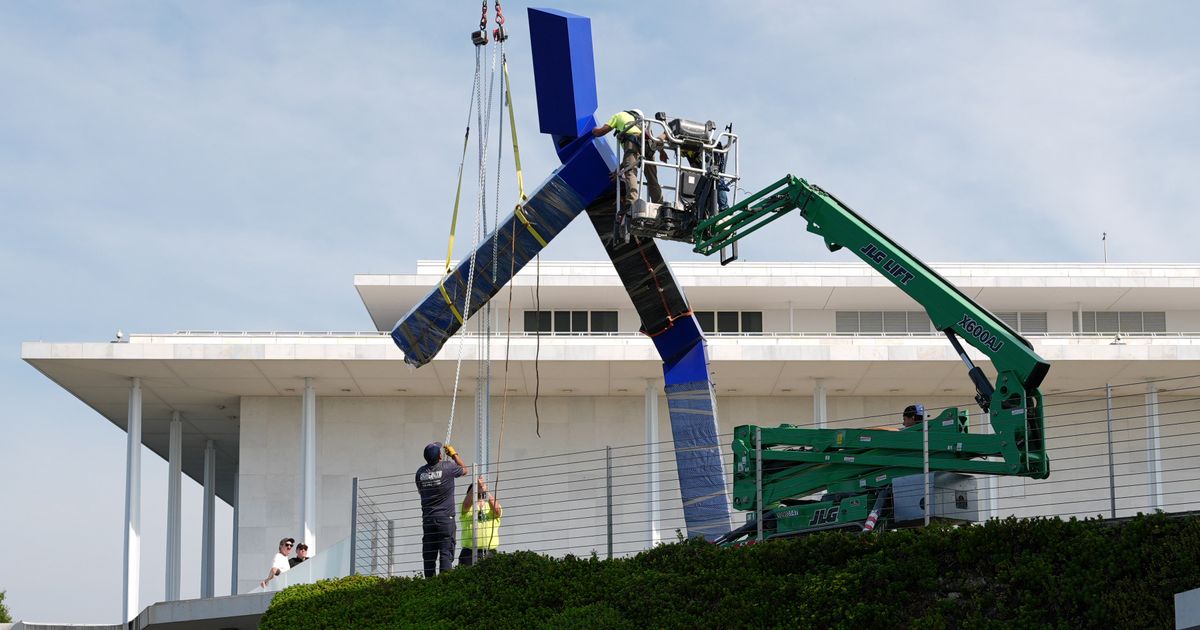 Workers remove the sculpture "Blue" by artist Joel Shapiro on the grounds of the John F. Kennedy Center for the Performing