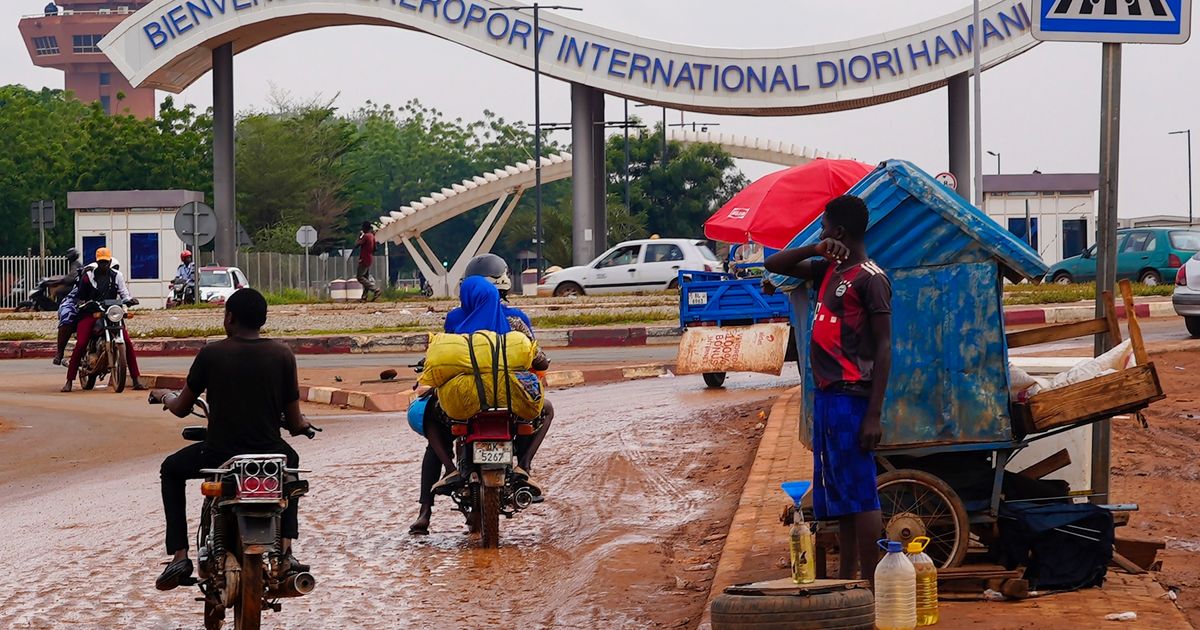 FILE - Motorcyclists ride by the entrance of the airport in Niamey, Niger, Aug. 8, 2023. (AP Photo/Sam Mednick, File)
