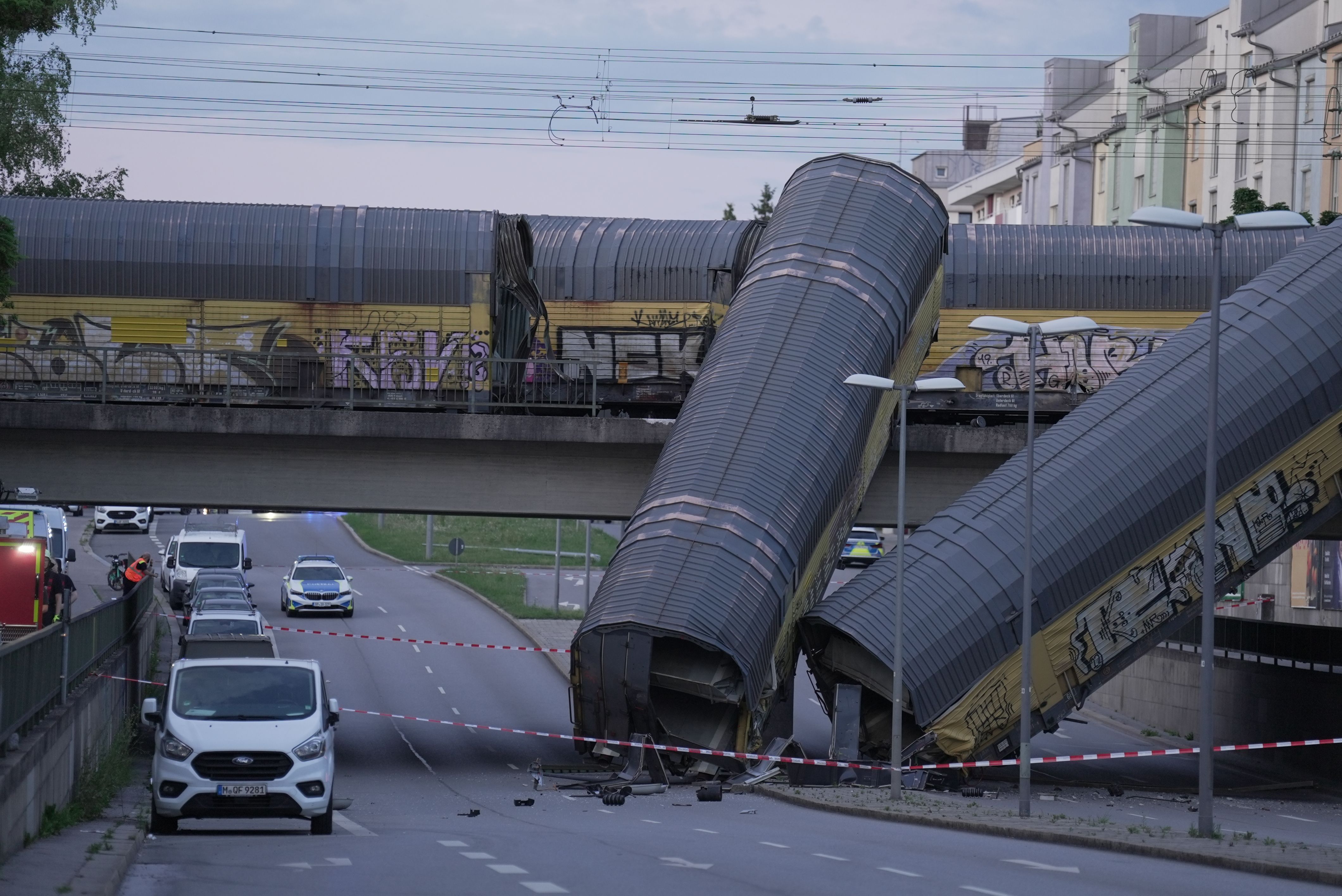 A freight train collision in Germany sends 2 wagons plunging off a bridge . One person was killed