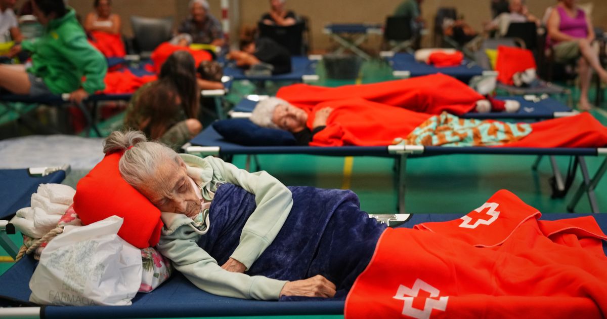 Tens of thousands of people flee raging wildfires in France and Spain, some escaping by boat