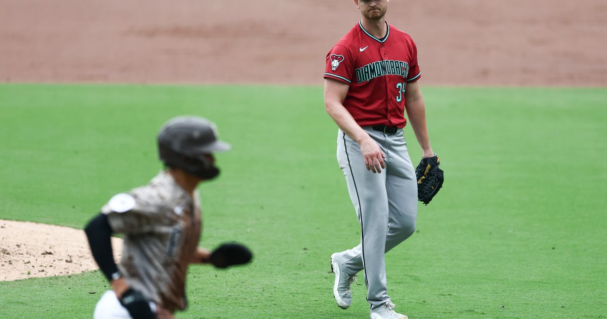 Arizona Diamondbacks starting pitcher Michael Soroka, right, looks on as San Diego Padres' Sung-Mun Song scores in the third