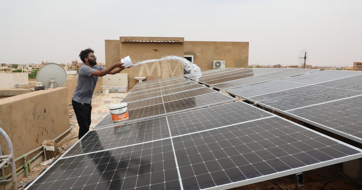 A technician cleans solar panels installed on the roof of a home in Omdurman, on the outskirts of Khartoum, Sudan, July 23