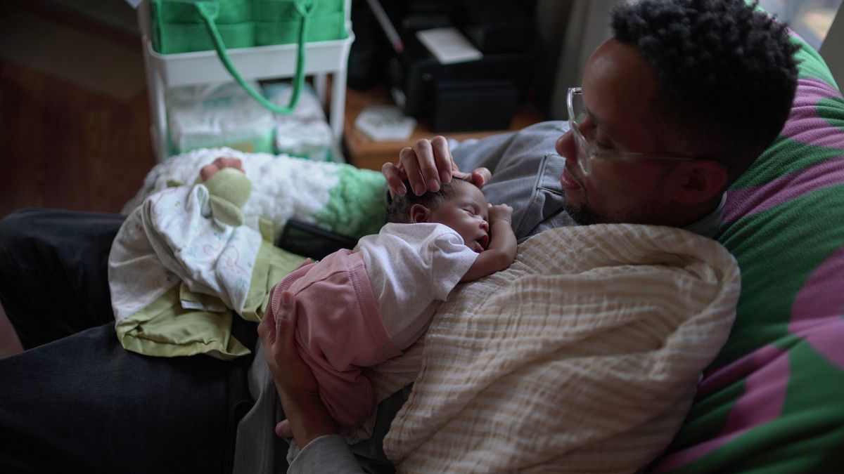 First-time dad JaKobi Burton holds his newborn daughter, Phoenix RyZen Reign Burton, at their home in Indianapolis, Nov. 13, 2025. (AP Photo/Obed Lamy)